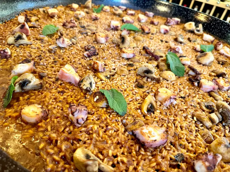 Close-up of rice with grilled octopus and mushrooms