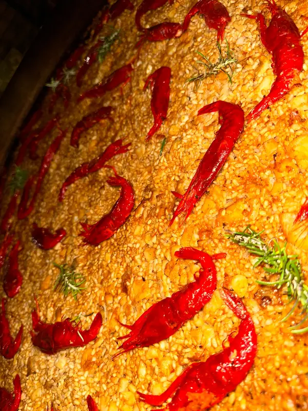 Close-up of rice with red prawns and rosemary