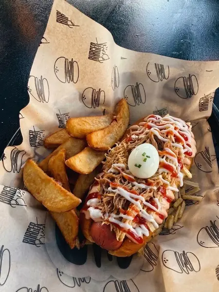 Beast Supreme Dog topped with pulled meats, sauces and a quail egg